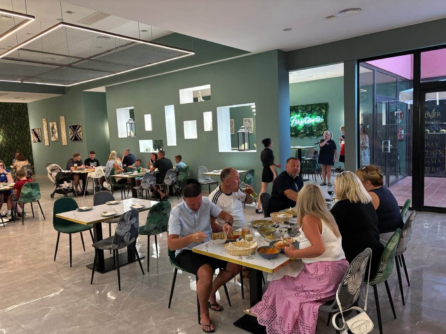 The Fusion dining room with sage walls, marble tables and botanical print chairs