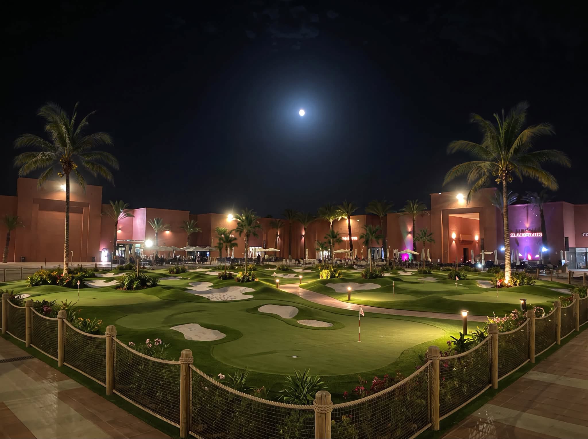 The course floodlit at night under a full moon